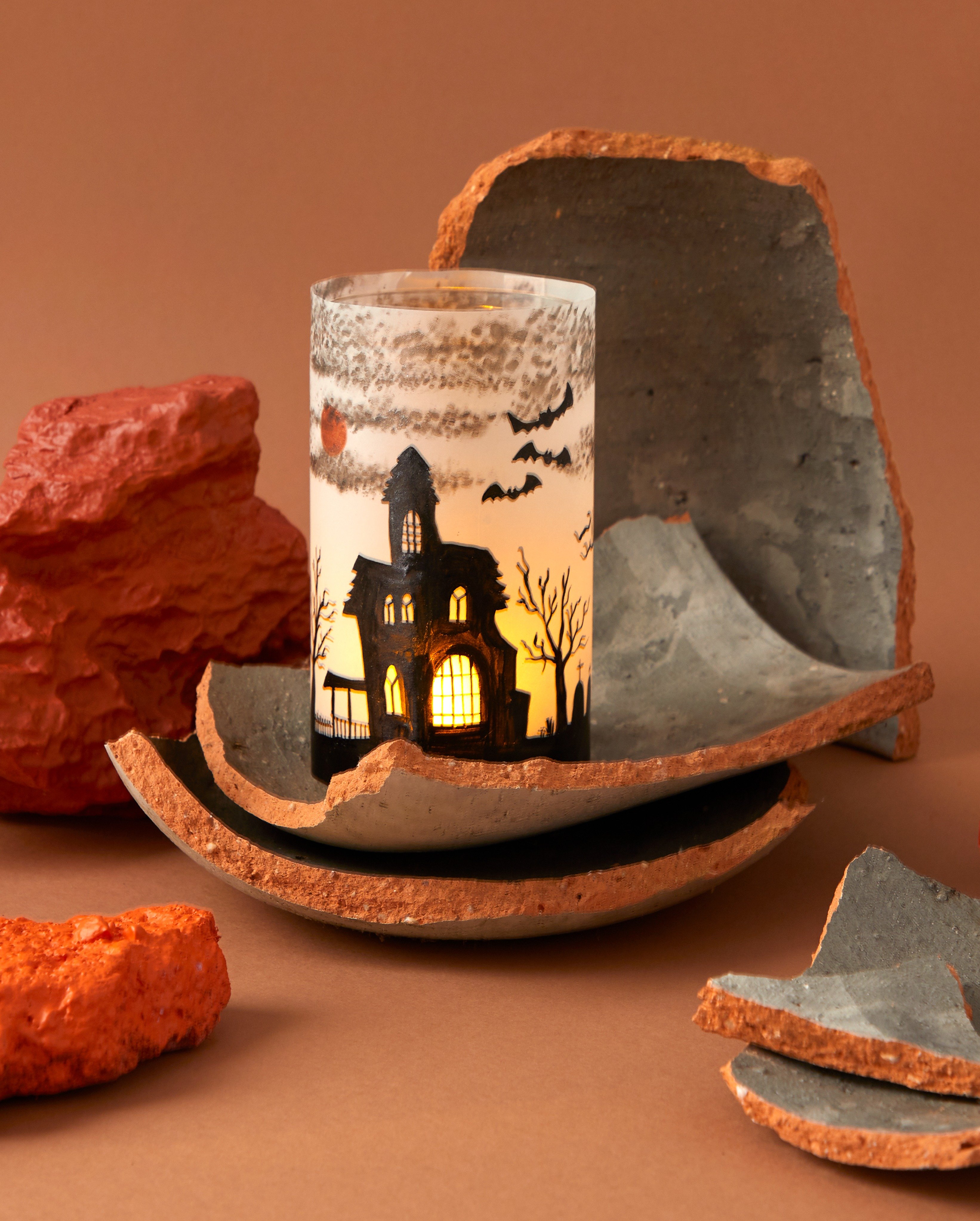 A Halloween haunted house candle jar